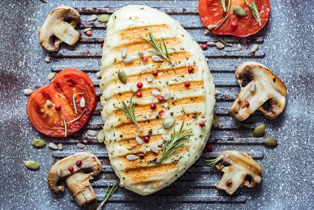 Queso halloumi frito de Chipre con tomates rojos y champiñones vista superior Comida equilibrada de cerca Cocinar en una sartén a la parrilla