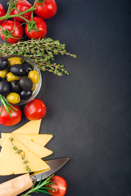 queso con hierbas frescas, aceitunas negras y verdes, tomates cherry, enfoque selectivo