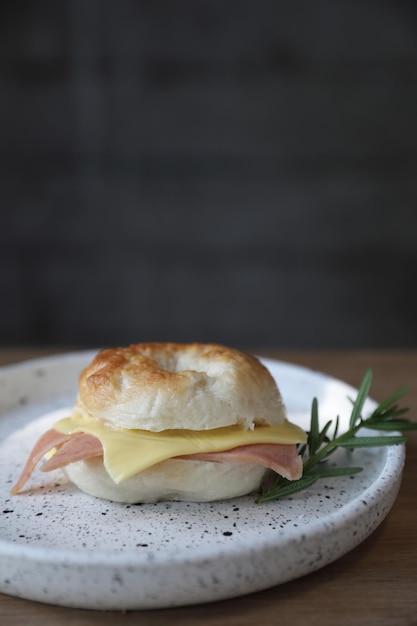 Queso de jamón bagel en primer plano sobre fondo de madera en la cafetería