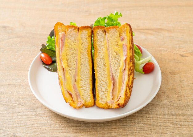 queso de jamón sándwich casero con ensalada en plato blanco