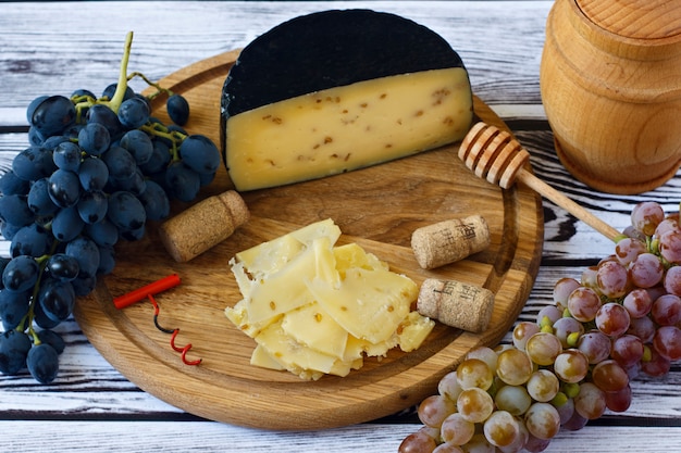 Queso Kachota en una tabla de madera sobre un fondo de madera con vino en un vaso