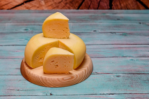 Queso de leche de cabra casero blanco redondo sobre tabla de madera