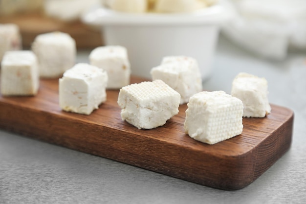 Queso en lonchas sobre tabla de cortar de madera