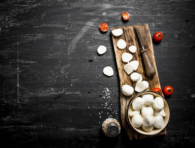 Queso mozzarella con cuchillo viejo y tomates.