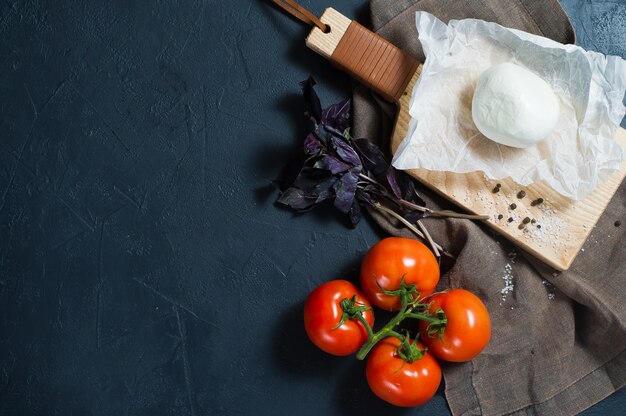 Queso mozzarella italiana, tomates, albahaca. Ingredientes para ensalada Caprese.