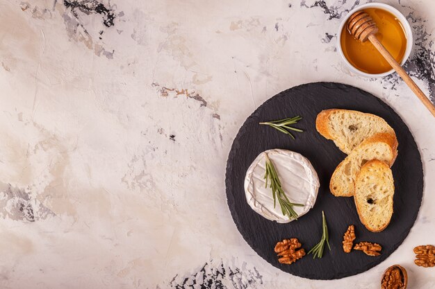 Queso, nueces y pan tostado en una tabla oscura