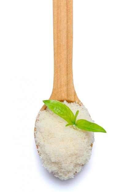 Queso parmesano rallado en cuchara de madera sobre mesa blanca