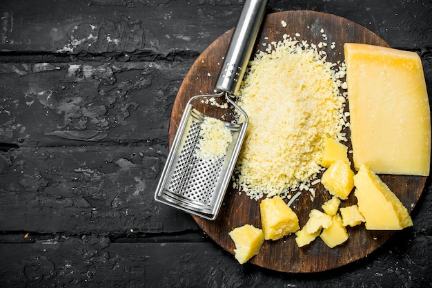 Foto queso parmesano rallado en una tabla de madera