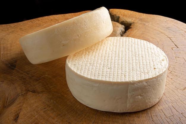 Queso semicurado de Brasil, hermoso queso brasileño dispuesto sobre madera rústica clara, enfoque selectivo.