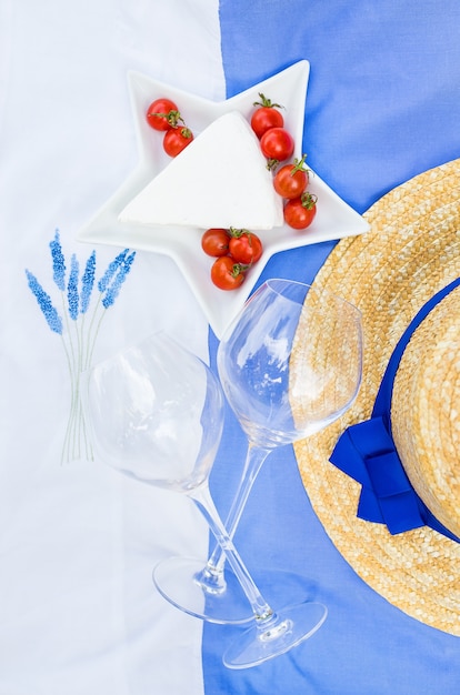 Queso, tomate y vasos con gorro de verano