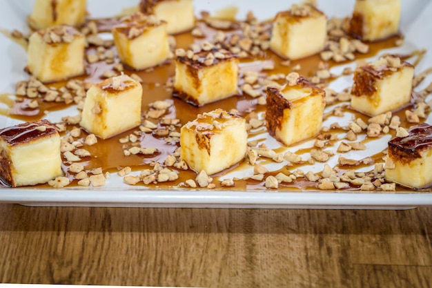 Queso tradicional de Brasil llamado Queijo coalho Servido con melaza de caña Sobre mesa de madera