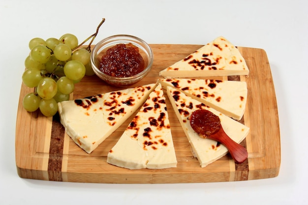 Queso tradicional de Laponia a la parrilla sobre tabla de cortar de madera. Queso chirriante de postre de Laponia