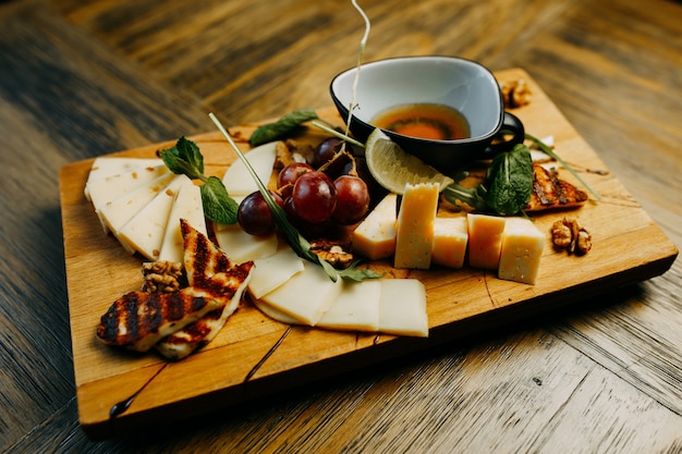 Queso y uva en la mesa de madera.