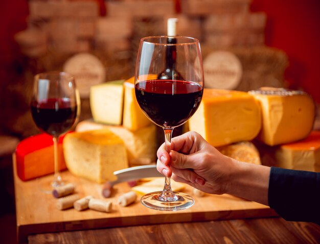 Queso y vino en una mesa oscura.