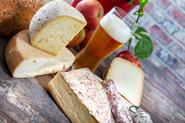 Quesos y aperitivos con cerveza, queso francés Saboya, Alpes franceses Francia.