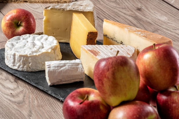 Quesos franceses con manzanas en la mesa de madera