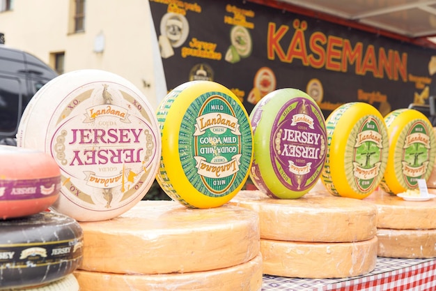 Quesos gourmet expuestos en un puesto de mercado europeo al aire libre