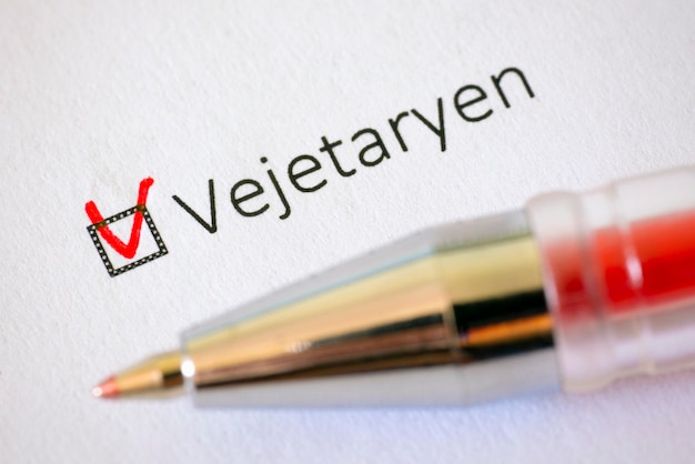 Questionário Caneta vermelha e a inscrição VEGETARIANA com marca de seleção no papel branco