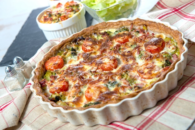 Quiche com brócolis, queijo e tomate, na toalha