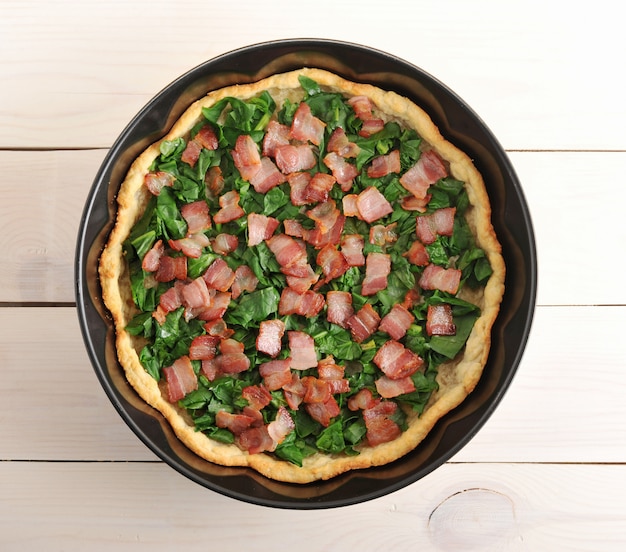 Quiche, espinacas y tocino en la fuente de horno