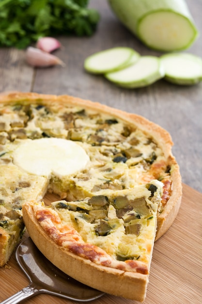 Foto quiche francés con verduras en una rústica mesa de madera