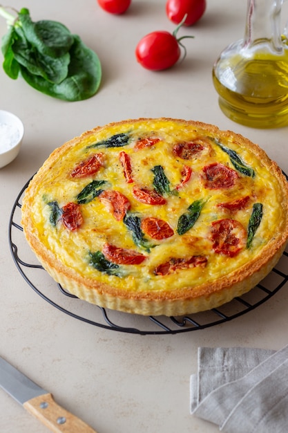 Quiche o pastel con tomates, espinacas y queso. Alimentación saludable. Comida vegetariana. Cocina francés.