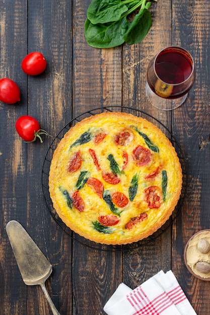 Quiche oder Kuchen mit Tomaten, Spinat und Käse. Gesundes Essen. Vegetarisches Essen. Französische Küche.