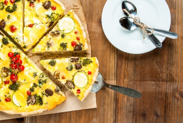 Quiche de tarta casera recién horneada en una mesa de madera