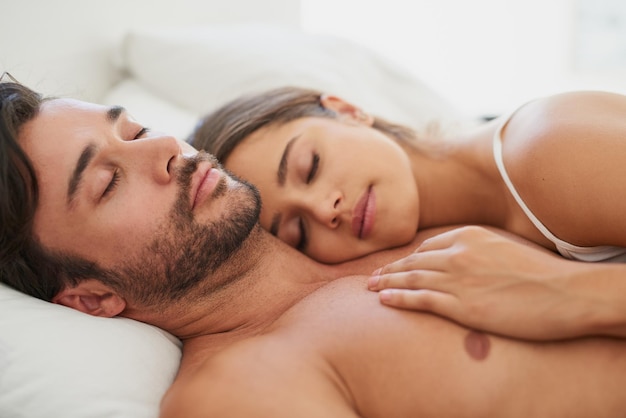 Quién necesita un osito de peluche cuando se tienen el uno al otro Foto de una pareja joven durmiendo cómodamente en la cama