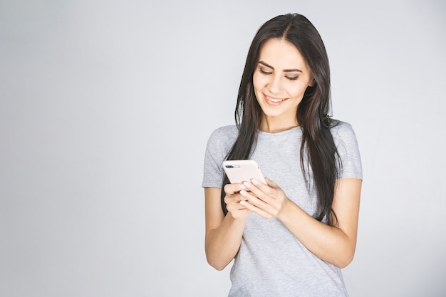 Quiero como en instagram! Ciérrese encima del retrato de la foto de la señora dentuda alegre alegre atractiva que usa sostener disponible celular aislado sobre el fondo blanco.