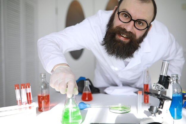 Químico louco Um cientista louco realiza experimentos em um laboratório científico Realiza pesquisas usando um microscópio