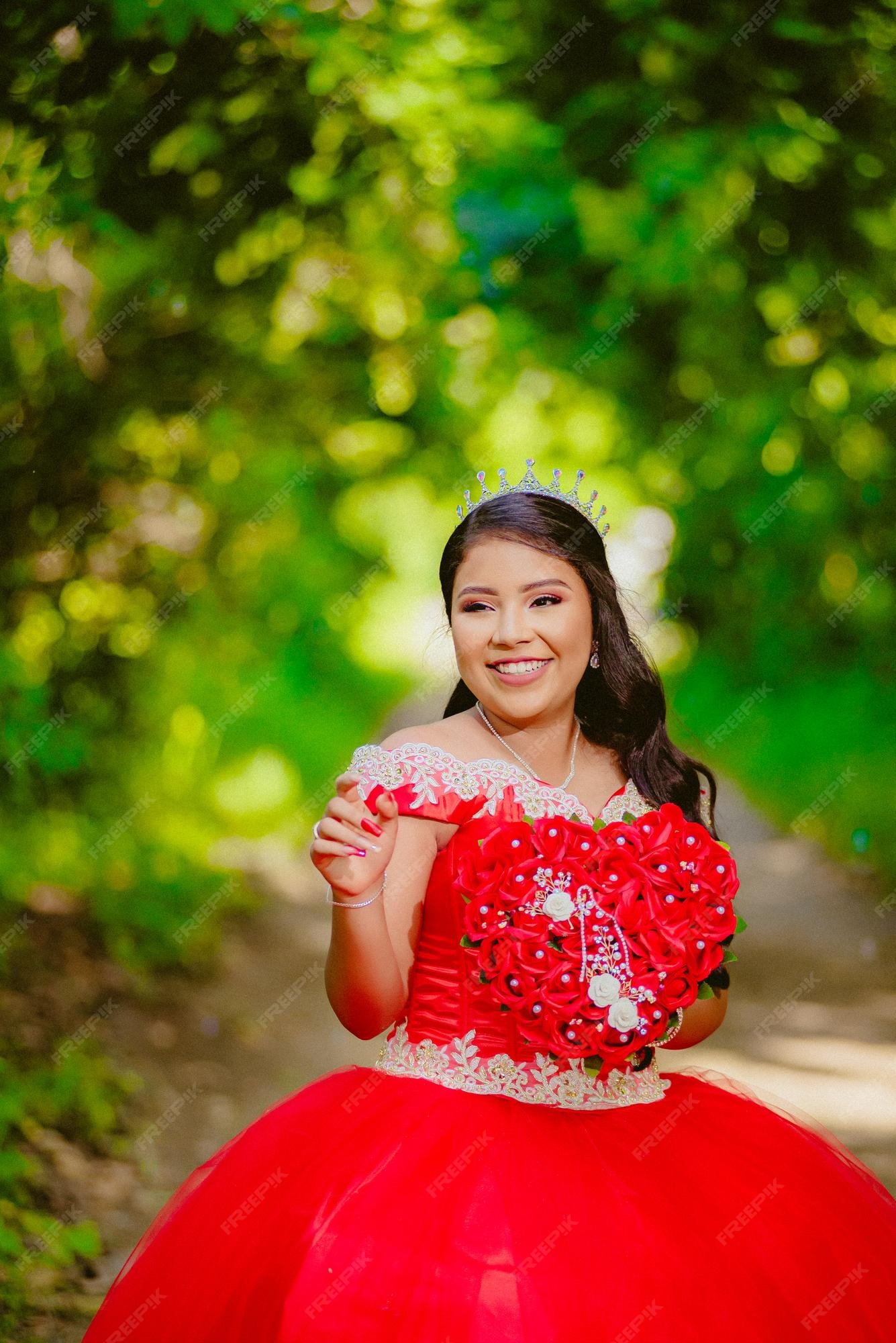 Quinceañera sonriente con un vestido el bosque | Foto Premium