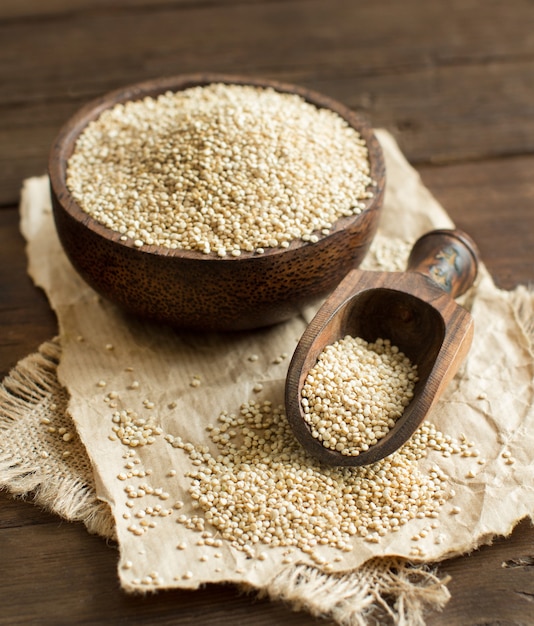 Quinoa branca em uma tigela com uma colher de pau close up