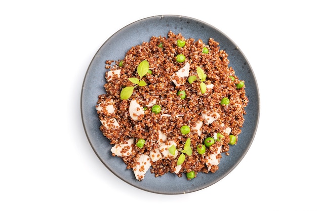 Quinoa Brei mit grüner Erbse und Huhn auf Keramikplatte isoliert auf weißer Oberfläche