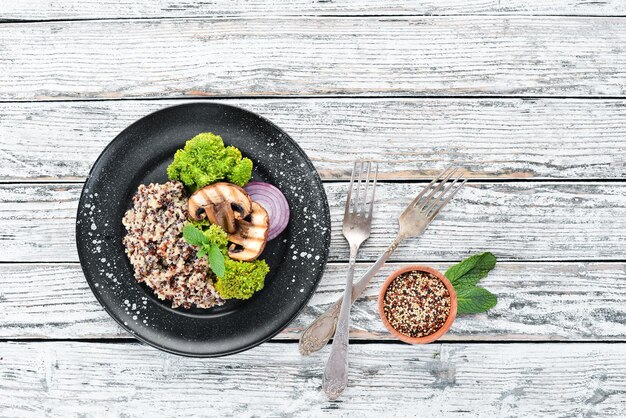 Quinoa com cogumelos e legumes em um prato Vista superior Espaço livre para o seu texto