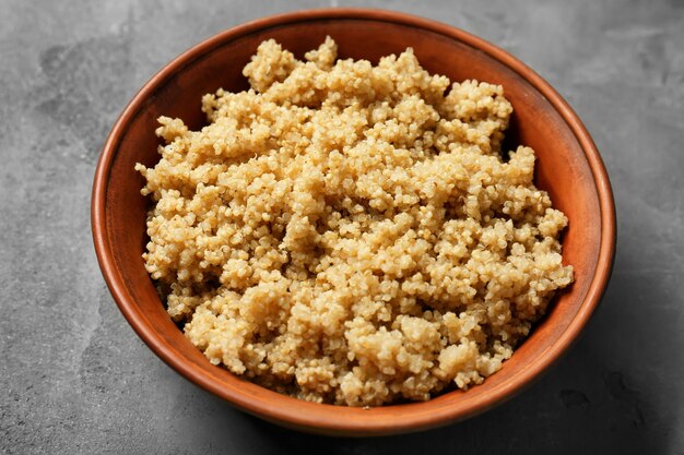 Quinoa cozida em uma tigela sobre uma superfície cinza | Foto Premium