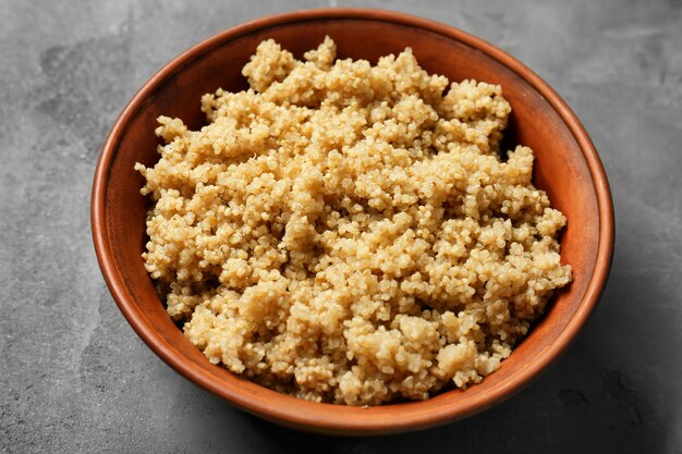 Quinoa cozida em uma tigela sobre uma superfície cinza