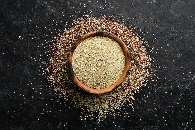 Quinoa in einer Holzschale. Gesundes Bio-Lebensmittel. Auf einem Steinhintergrund. Ansicht von oben.