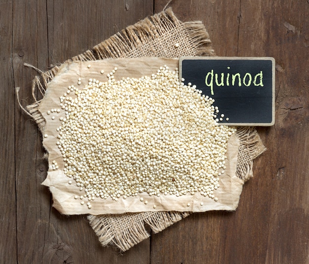 Foto quinoa orgânica com uma pequena lousa em uma mesa de madeira