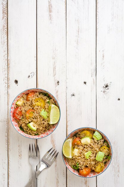 Quinoa-Salat in der Schüssel auf weißem Holztisch