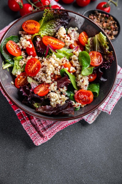Quinoa-Salat Tomate grüne Blattmischung gesunde Mahlzeit Lebensmittelsnack auf dem Tisch kopieren Raum Lebensmittelhintergrund