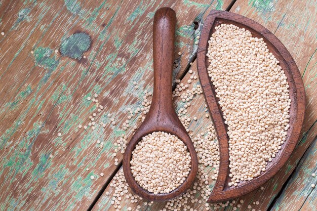 Quinoa-Samen in Schüssel auf rustikalem Holz