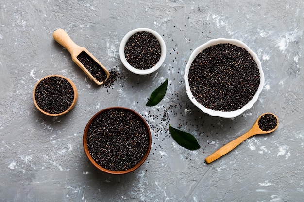 Quinoa-Samen in Schüssel und Löffel auf farbigem Hintergrund Gesundes Kinwa in kleiner Schüssel Gesundes Superfood