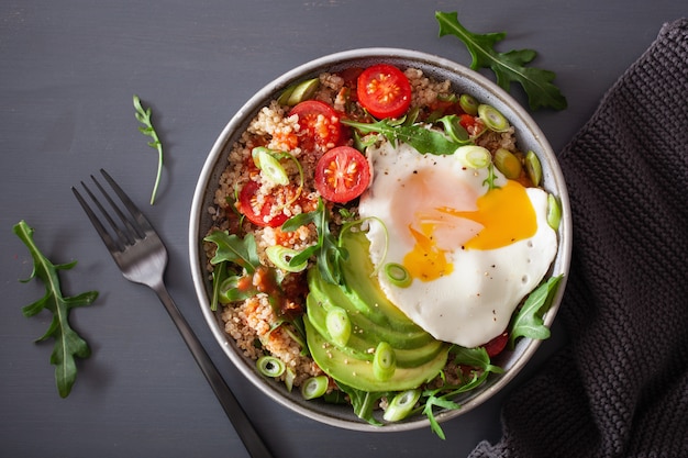 Quinoa-Schüssel mit Spiegelei, Avocado, Tomate, Rucola. Gesundes vegetarisches Mittagessen