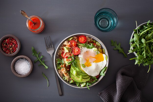 Quinoa-Schüssel mit Spiegelei, Avocado, Tomate, Rucola. Gesundes vegetarisches Mittagessen