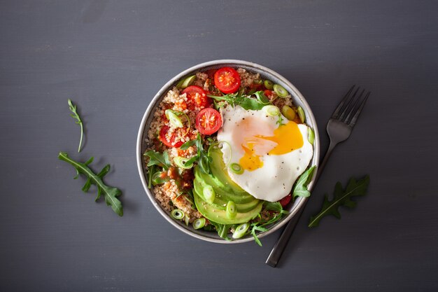 Quinoa-Schüssel mit Spiegelei, Avocado, Tomate, Rucola. Gesundes vegetarisches Mittagessen