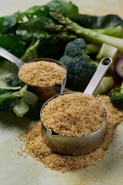 Foto quinoa seca em copo de medição e vegetais verdes conceito de cozinha sem glúten e saudável