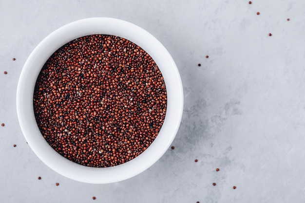 Foto quinoa semillas de quinua roja cruda en un tazón sobre fondo de piedra gris vista superior espacio de copia