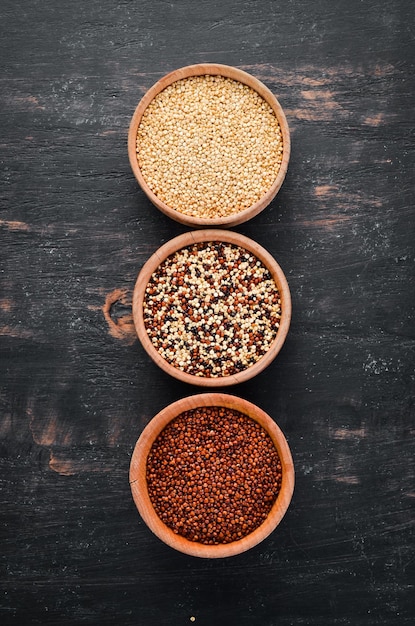 Quinoa-Set Rote, weiße und braune Quinoa auf schwarzem Hintergrund Draufsicht Freier Kopierbereich