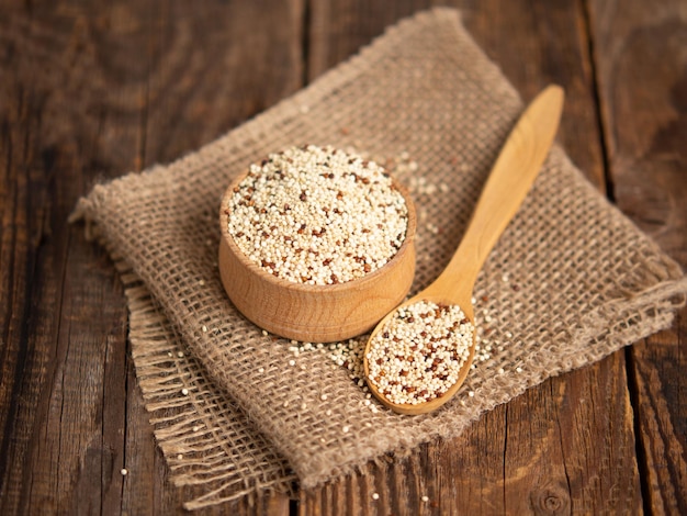 Quinua cruda mixta en tazones sobre un fondo de madera Alimentos saludables y sin gluten